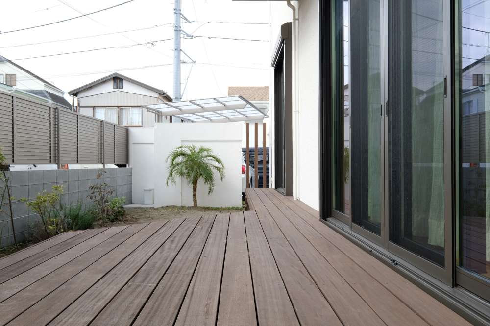 目隠しフェンスでプライバシーを保護したハードウッドデッキ空間。