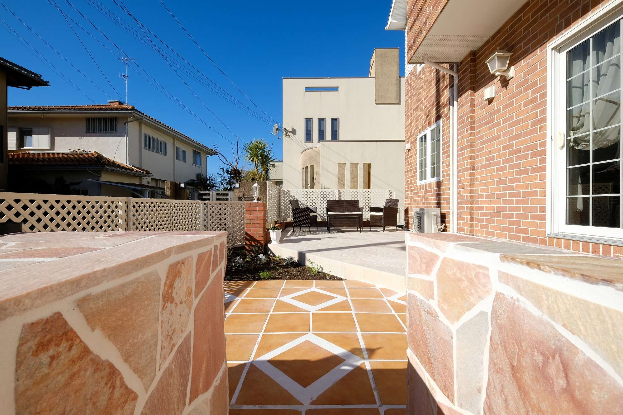 ガーデンキッチンの先に続くタイルテラス