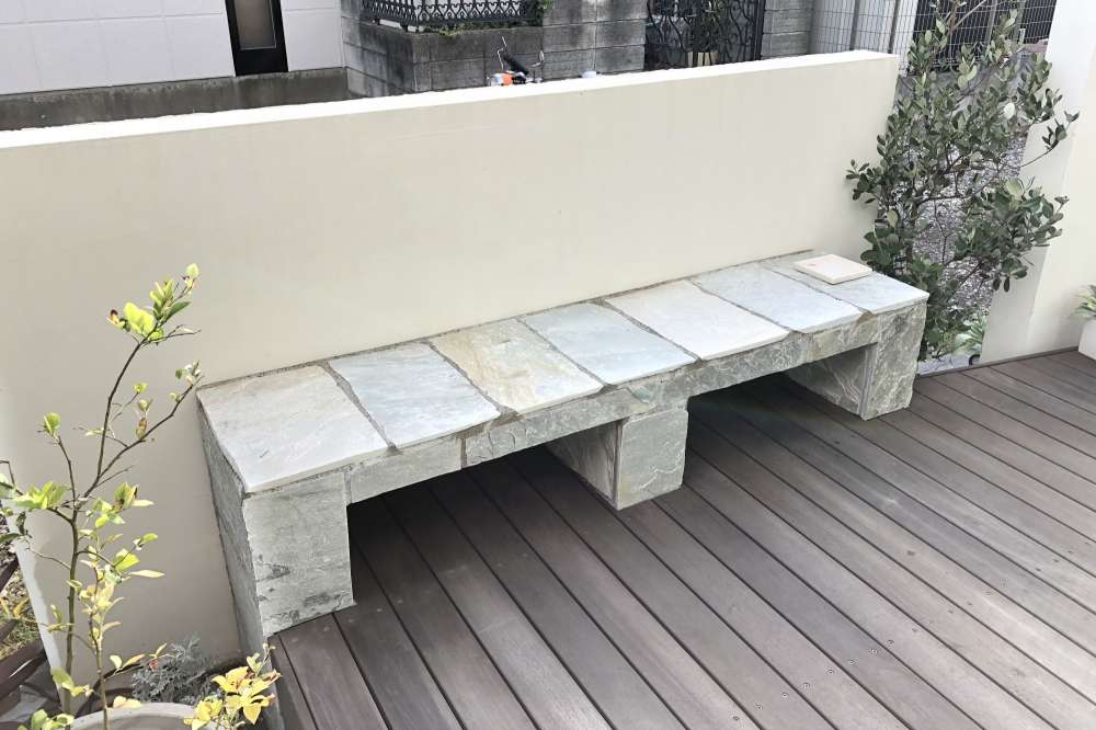 自然石のベンチをウッドデッキとともに