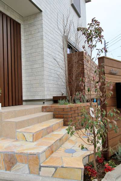 石張り階段アプローチ、レンガ積み花壇、ウッド門柱、シンボルツリー