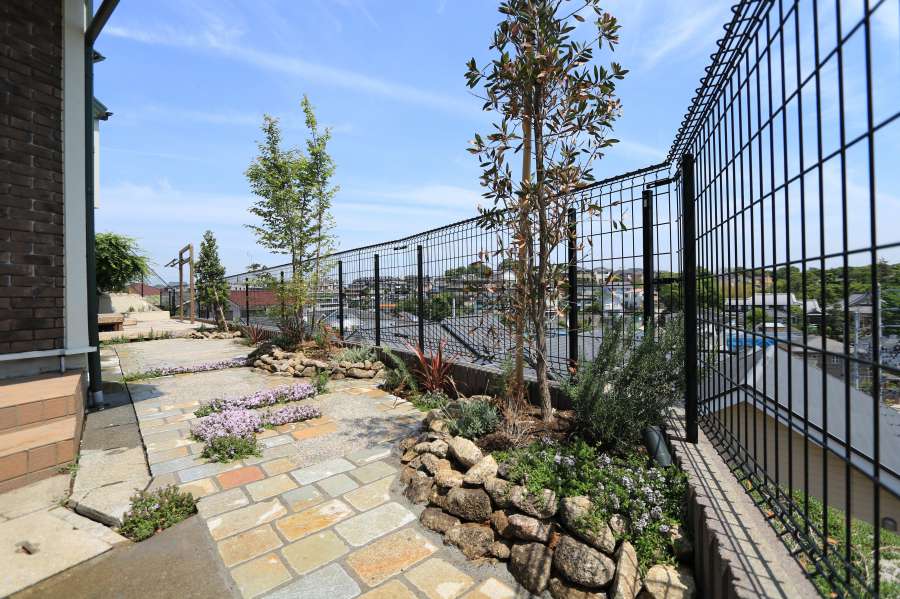 ごろた石組みの花壇とシンボルツリー