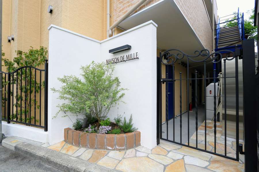 鋳物門扉・白い壁・植栽のエントランス