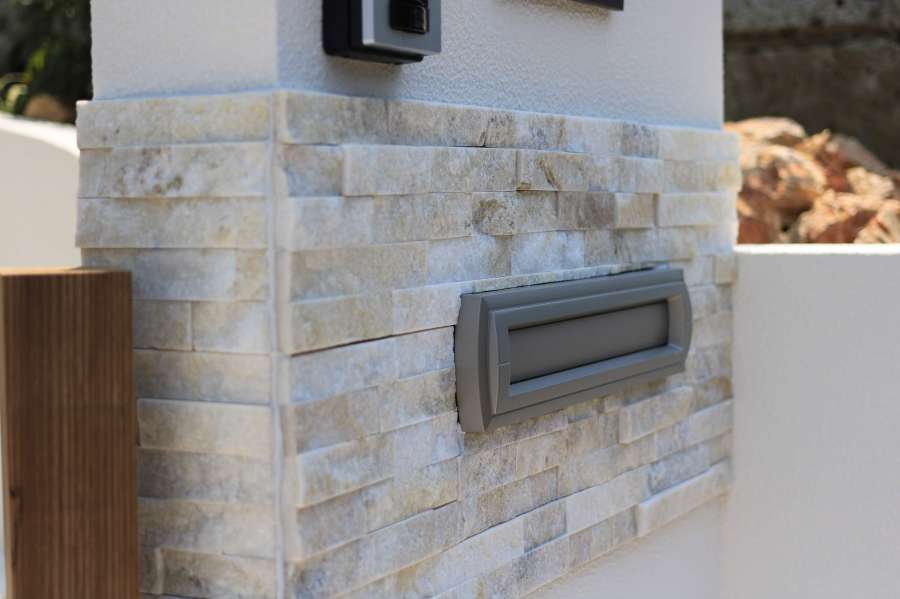 石張りをアクセントに使った白い壁の門柱