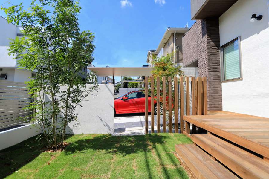 施主様自ら張った芝生の奥には、枕木立てと赤い車