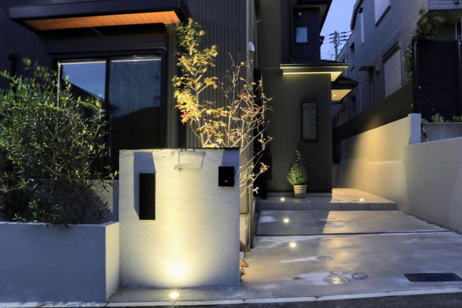 建物外壁の黒を引き立てる、グレートーンのファサードとグラウンドライト