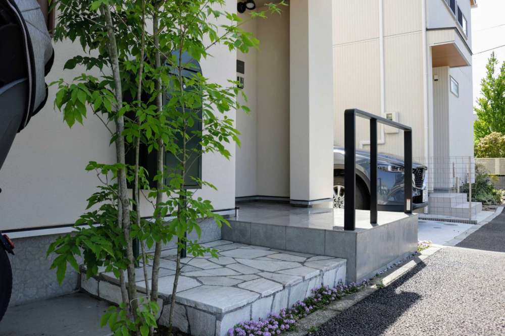 玄関ポーチを拡張することで、玄関前にスペースができ、出入りに余裕が生まれます 階段下にはクリーピングタイムが花を咲かせていました