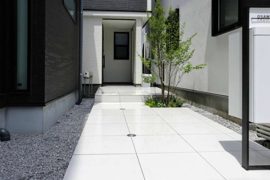 白タイルの明るくのびやかなアプローチ