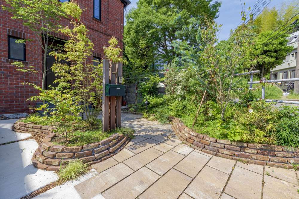 雑木やレンガを組合せたナチュラルな外構